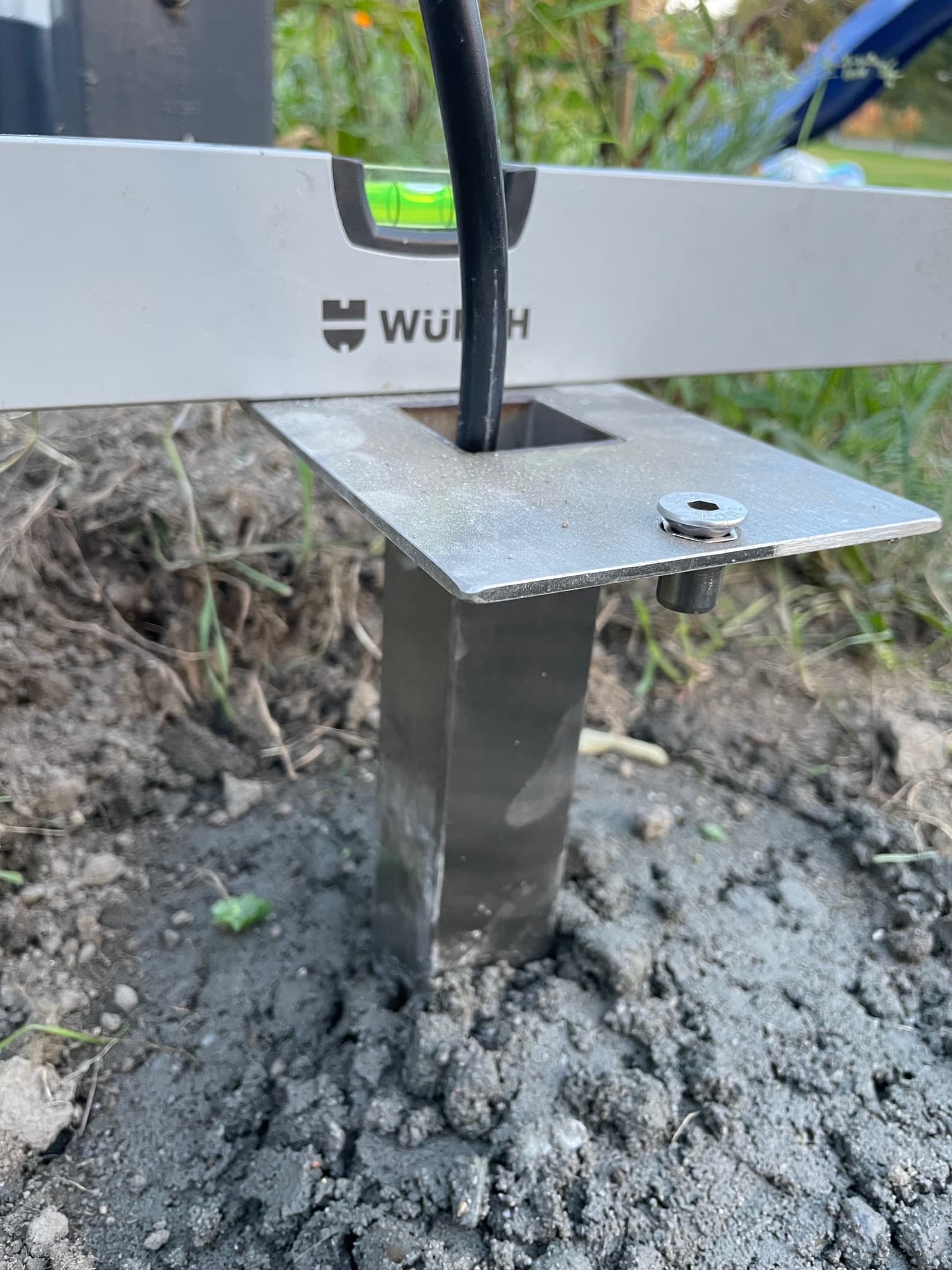 kabel ziemny yky przeciągnięty pod ziemią przez peszlę do podstawy słupka ogrodowego